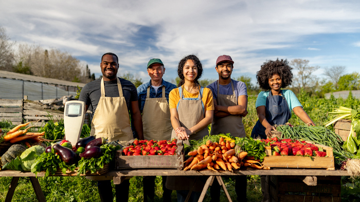 Happy group of farmers selling their produce at a Farmer's Market