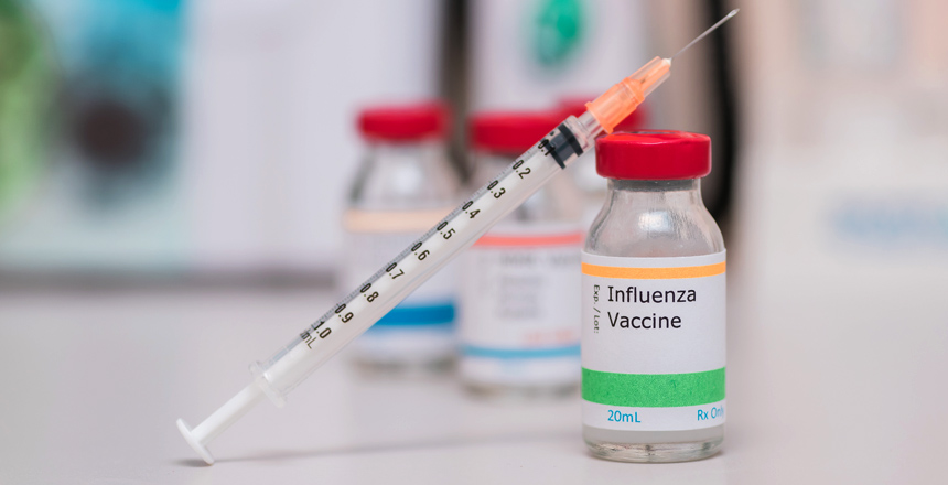 influenza vaccination concept with syringe in vaccine vial and o